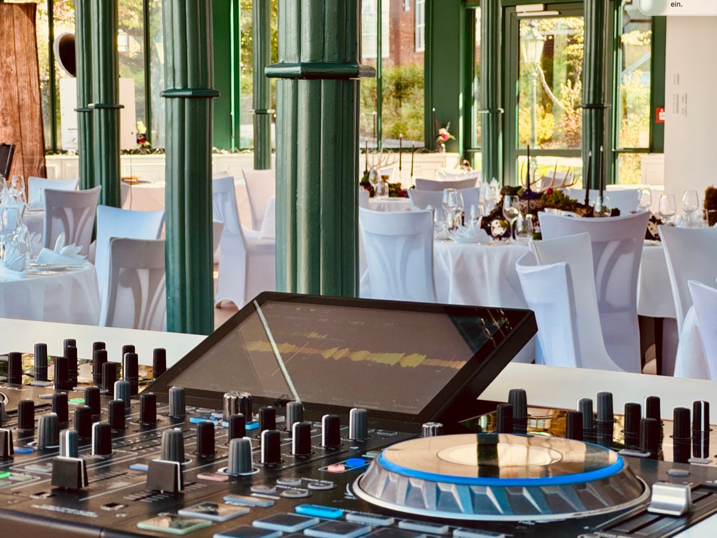 Blick über das DJ-Pult auf gedeckte Tische im Pavillon des Parkhotel Adler
