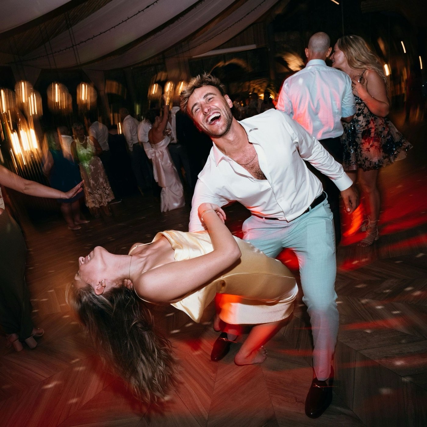 A couple laughing and dancing on a full dance floor